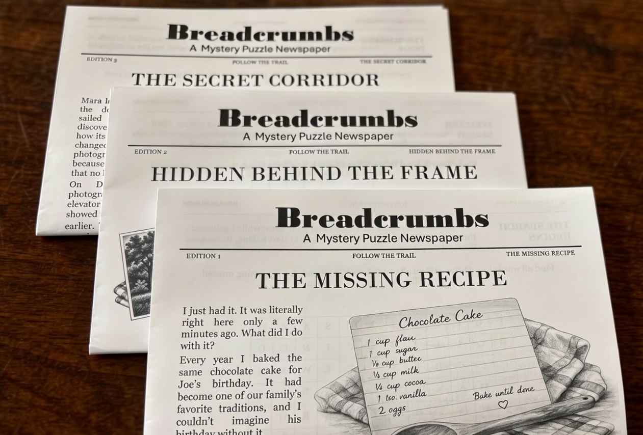 Three original printed Breadcrumbs mystery puzzle newspaper editions arranged on a wooden table